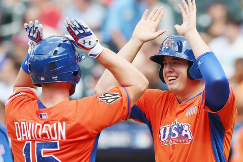 Angels prospect C.J. Cron congratulates Matt Davidson after his home run in the fourth inning of the Futures game Sunday at Citi Field.