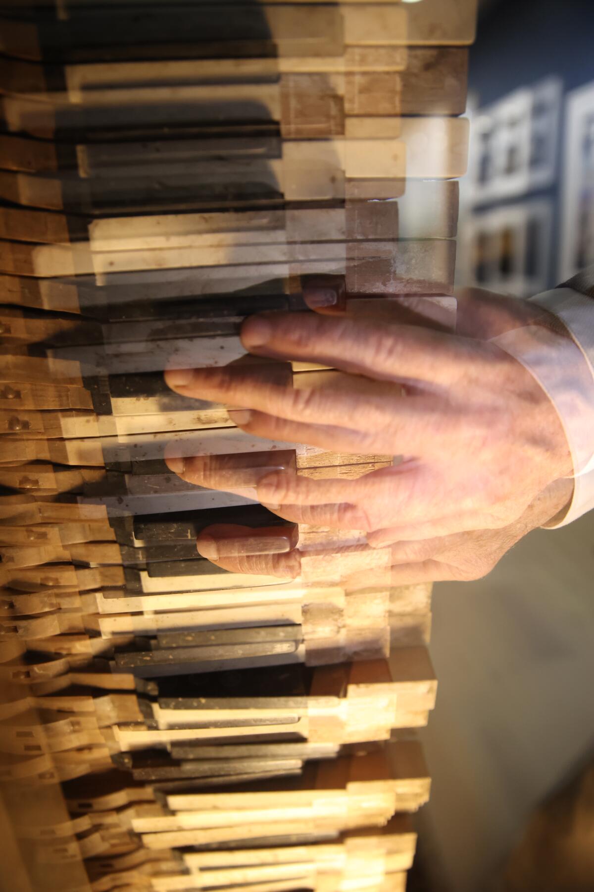A blurred image of a person's hand playing keys of an antique piano