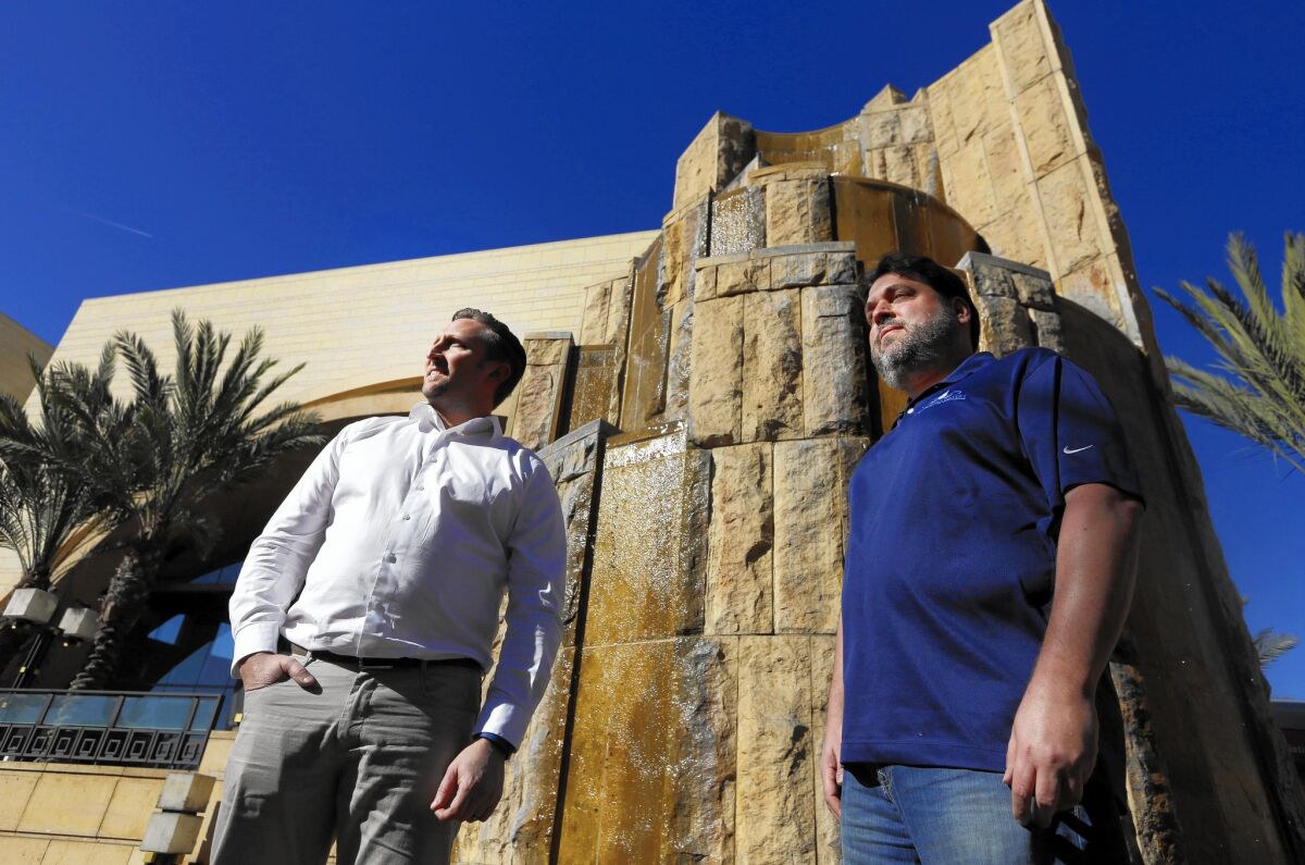 Mark Pitman, left, and Jeffrey Barman, co-owners of California Waters, a business that designs, installs and repairs decorative fountains, stand next to the Arroyo Fountain at L.A.'s Union Station.