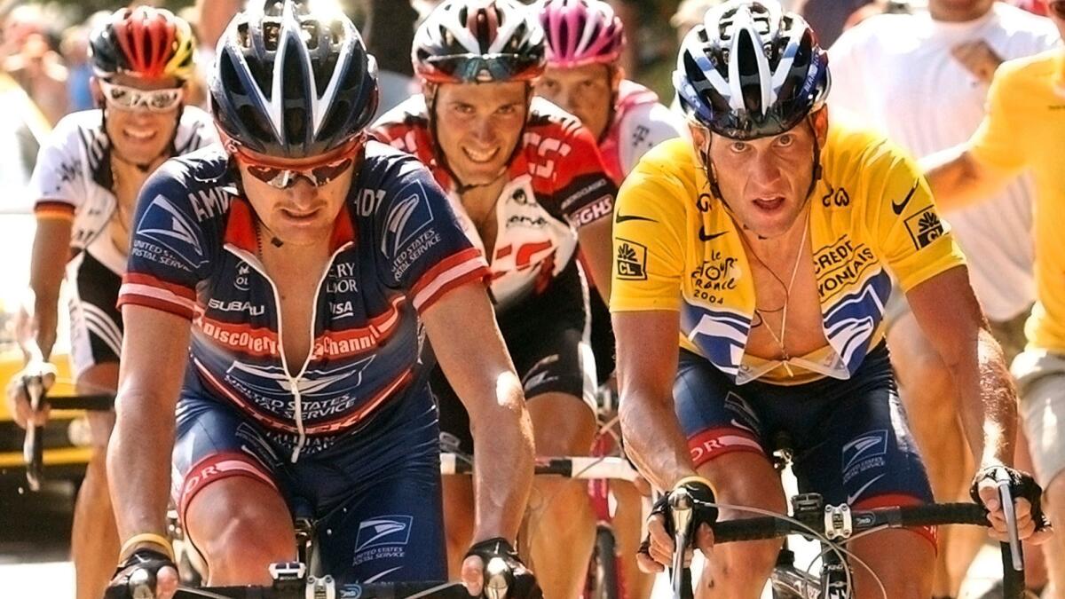 In this 2004 photo, overall leader Lance Armstrong, right, of Austin, Texas, follows compatriot and teammate Floyd Landis, left, in the ascent of the La Croix Fry pass during the 17th stage of the Tour de France cycling race.