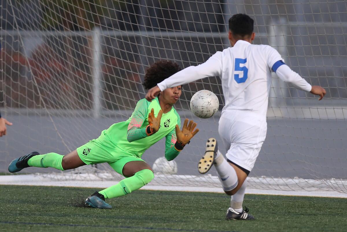 Newport Harbor goalkeeper Briant Alvarez stops a shot by La Habra’s Sebastian Romero (5) in the second round of the CIF Southern Section Division 2 playoffs on Friday.