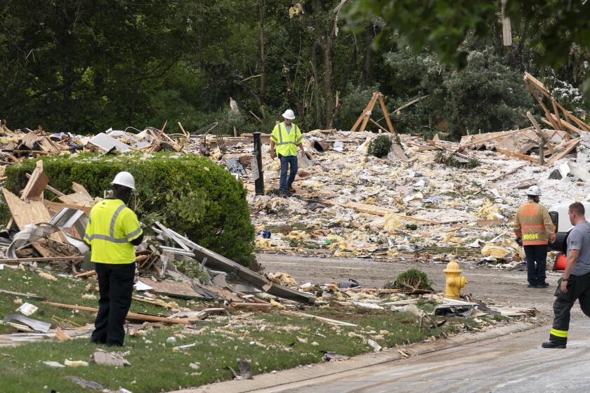 Trabajadores de la construcción retiran escombros tras la explosión de una vivienda, el domingo 11 de agosto de 2024, en Bel Air, Maryland. (AP Foto/José Luis Magaña)