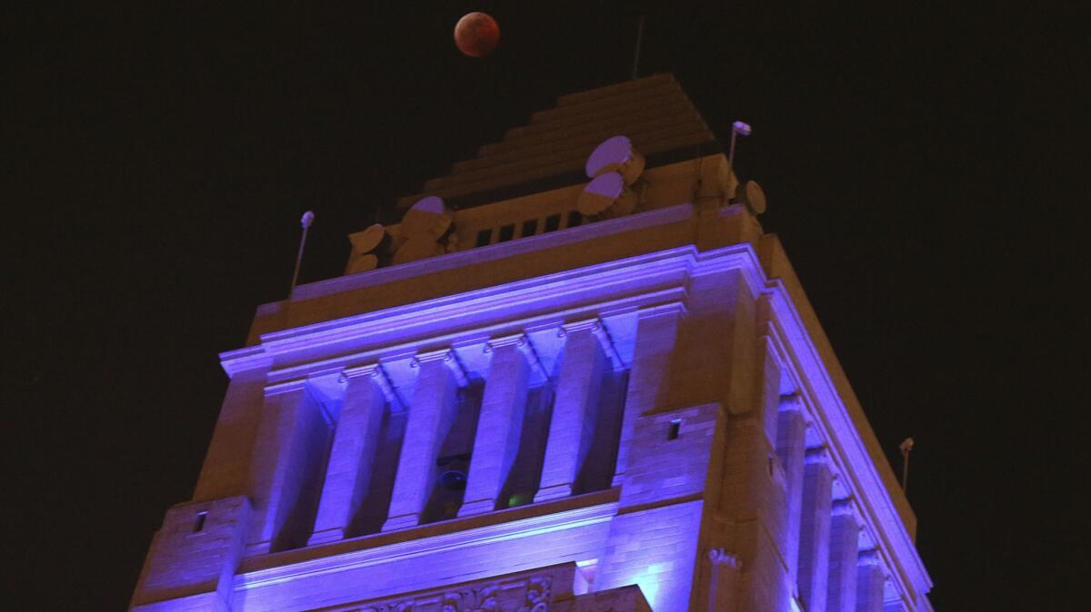 The moon hangs over Los Angeles City Hall on Jan. 20.