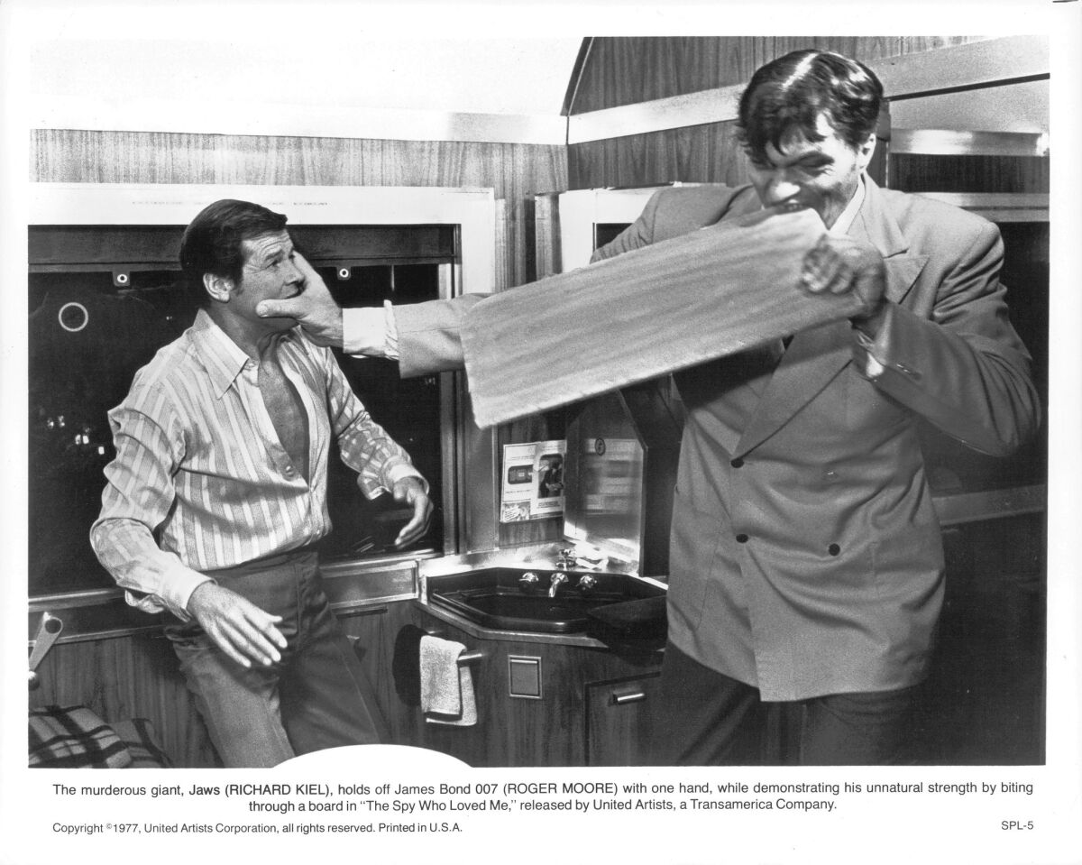 Roger Moore fights with Richard Kiel, as Jaws, who bites through a board in a scene from the film 'The Spy Who Loved Me' (1977).