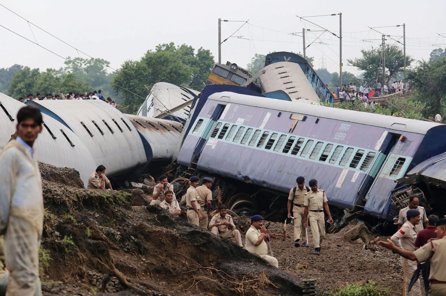 Indian policemen take a rest at the site of a train accident near Harda in central India. At least 24 people died when two passenger trains derailed after heavy monsoon rains flooded railway tracks.