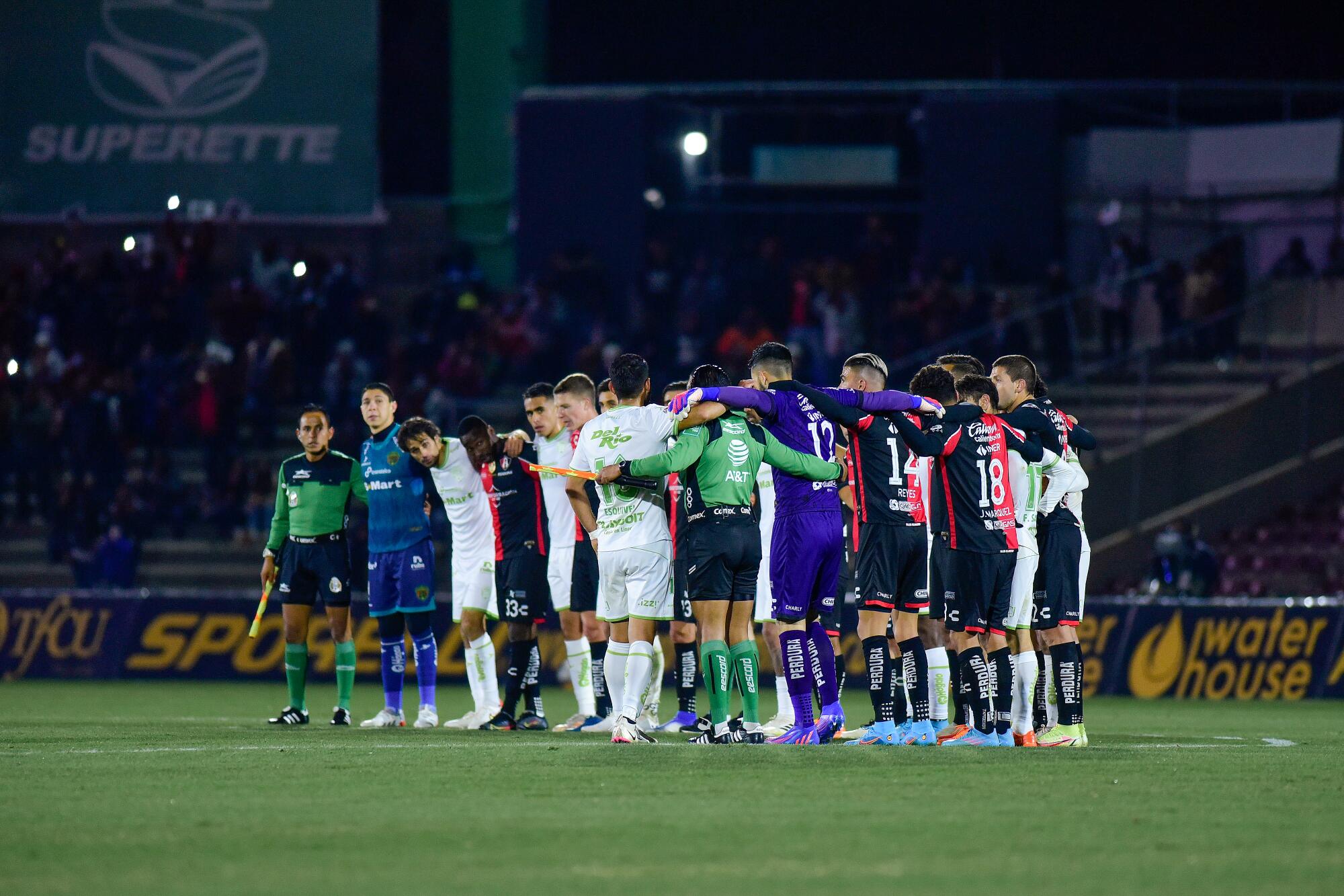 Players of Juarez and Atlas huddle to promote peace.