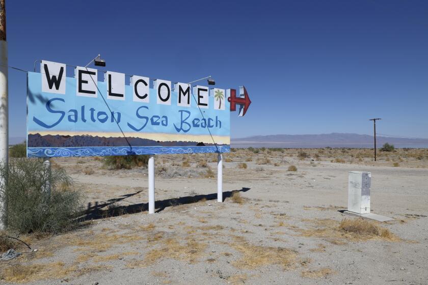 Imperial Valley, CA - September 24: A welcome sign stands at the entrance to Desert Shores next to the shrinking Salton Sea in the Imperial Valley. Some are concerned that the Imperial Irrigation District's water-saving program is worsening the decline of the Salton Sea and contributing to lung-damaging dust. Photo taken Wednesday, Sept. 25, 2024. Many Imperial Valley farmers are voluntarily participating in a multimillion dollar Colorado River deal in which the federal government that is paying farmers in the Imperial Valley to leave their hay fields dry during part of the year in exchange for payments. The agreement has recently become controversial because the Sierra Club has sued the irrigation district, saying it has failed to address the effects of the water reduction on the shrinking Salton Sea, which is fed by farm runoff. The shrinking of the sea is leading to more dust in the area, which poses a health threat and has been linked to high asthma rates among children in the area. Some residents are concerned about the shrinking of the Salton Sea. (Allen J. Schaben / Los Angeles Times)