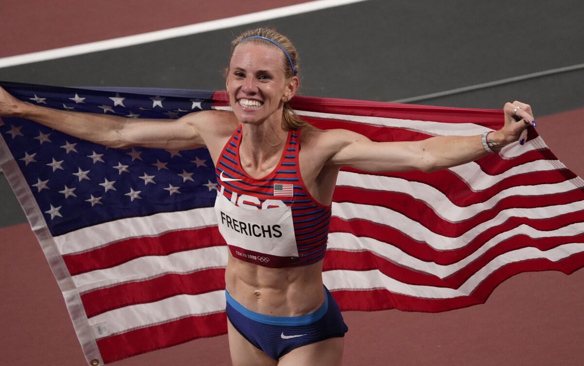 Courtney Frerichs holds a U.S. flag after the women's 3,000-meter steeplechase at the Tokyo Olympics.