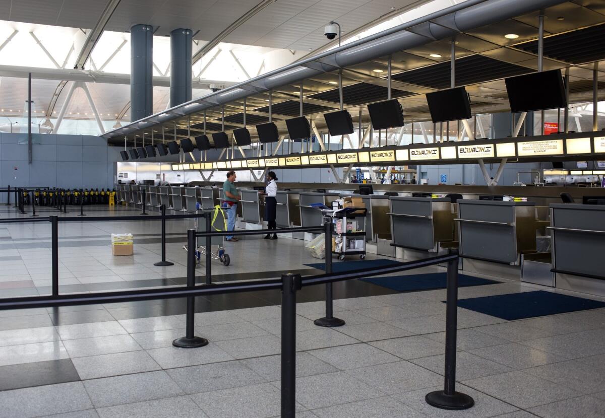 Two people stand at the El Al Airlines ticket desk at Terminal 4 in New York's John F. Kennedy Airport on Tuesday. The Federal Aviation Administration halted all flights from the United States to Tel Aviv after a rocket attack near Ben Gurion International Airport.