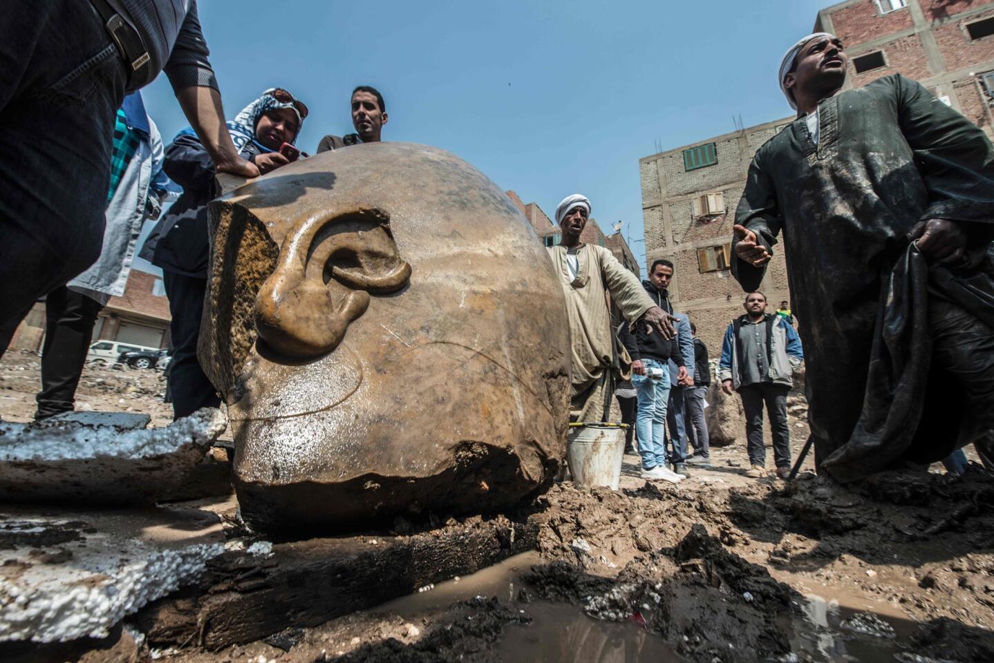 Egyptian workers look at the site of a discovery by a team of German-Egyptian archaeologists in Cairo's Mattarya district. Statues of the kings and queens of the 19th dynasty (1295-1185 B.C.) were unearthed in the vicinity of the Temple of Ramses II in what was the old pharonic city.