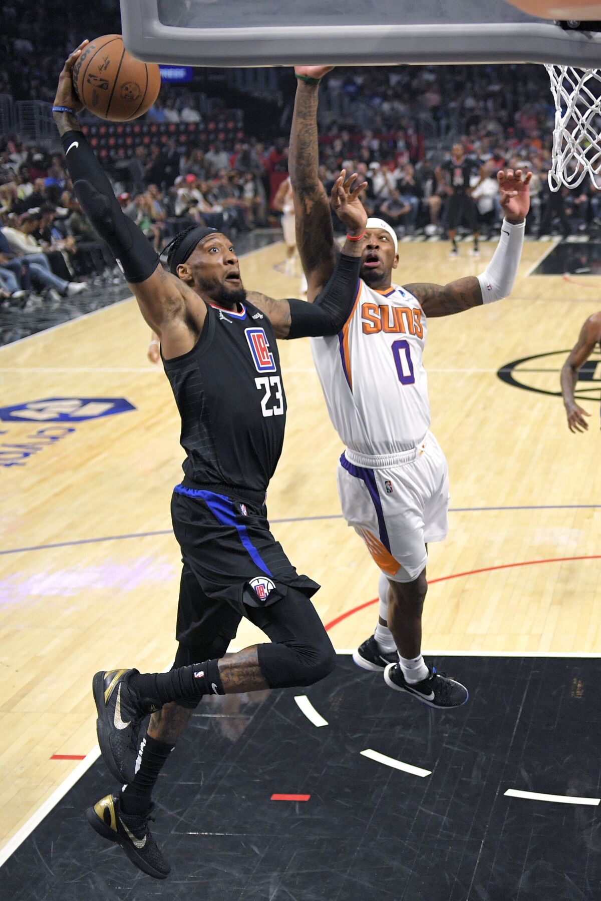 Clippers forward Robert Covington shoots as Phoenix Suns forward Torrey Craig defends.