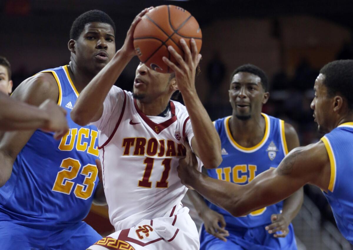 USC guard Jordan McLaughlin drives to the lane between a host of UCLA defenders on Jan. 14, 2015.