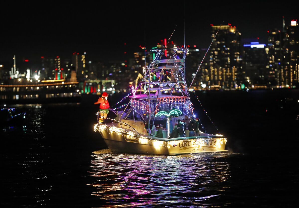 A boat decorated in Christmas lights on San Diego Bay at night