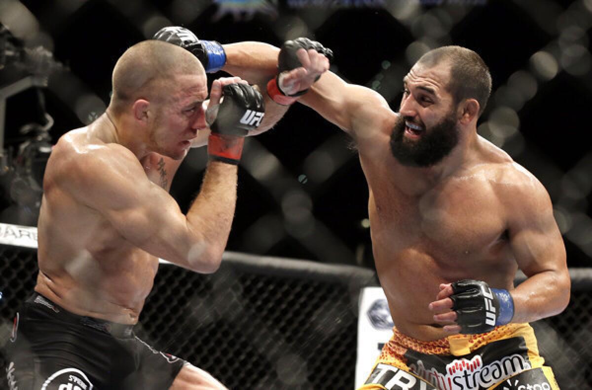 Georges St-Pierre, left, and Johny Hendricks exchange punches during their welterweight title fight at UFC 167 last year.