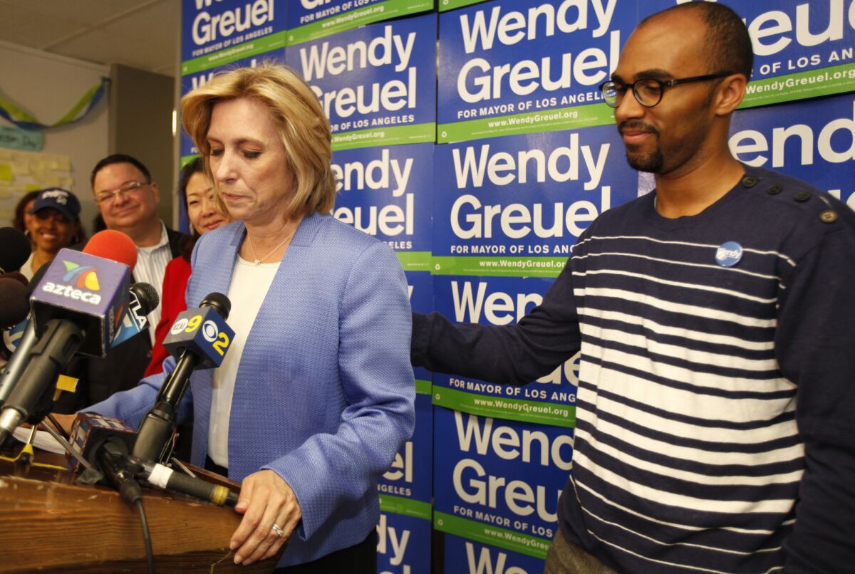 Wendy Greuel is consoled by supporter Todd Hawkins while addressing a press conference pledging her support to Eric Garcetti based on election results in the Los Angeles Mayoral campaign.