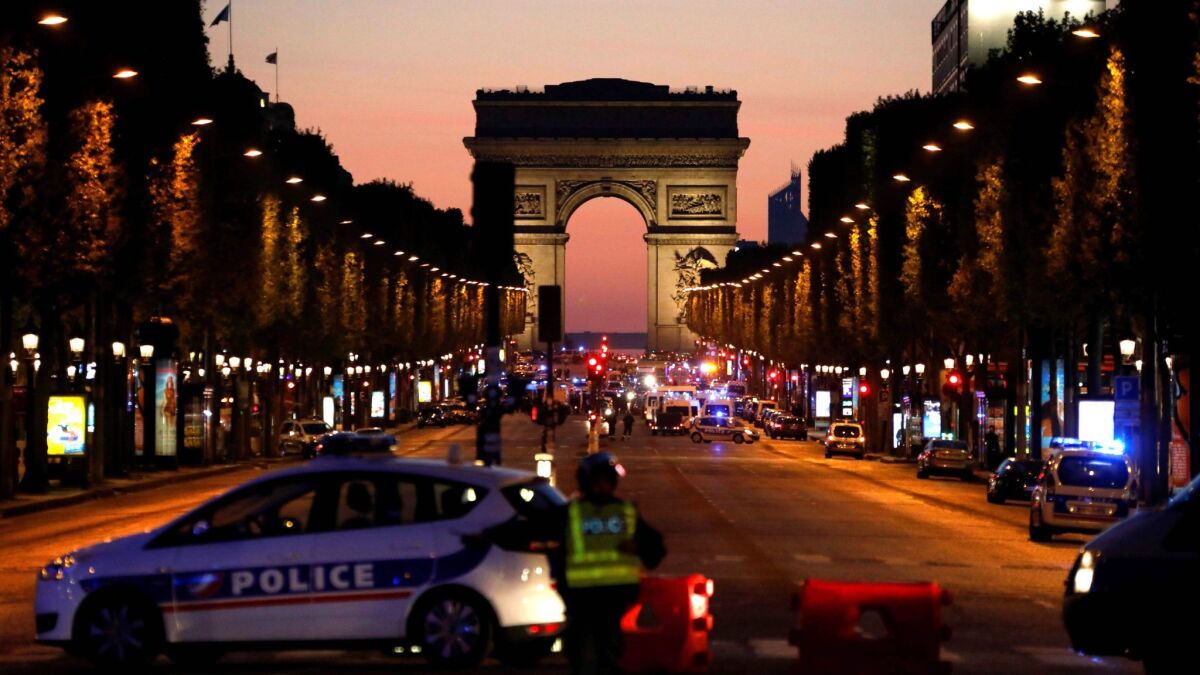 Police officers block the access to the Champs Elysees in Paris after a shooting.