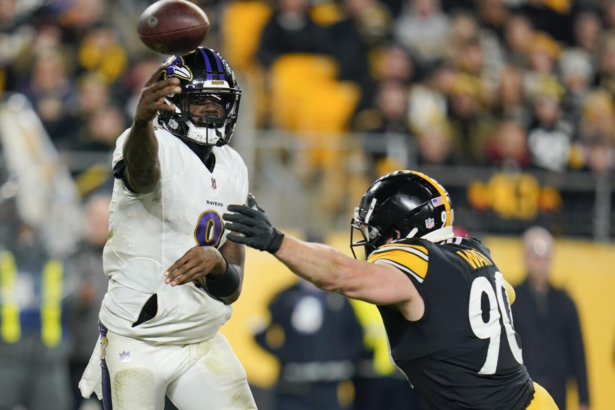 Baltimore Ravens quarterback Lamar Jackson (8) passes as Pittsburgh Steelers Pittsburgh Steelers outside linebacker T.J. Watt (90) pressures him during the first half of an NFL football game, Sunday, Dec. 5, 2021, in Pittsburgh. (AP Photo/Gene J. Puskar)