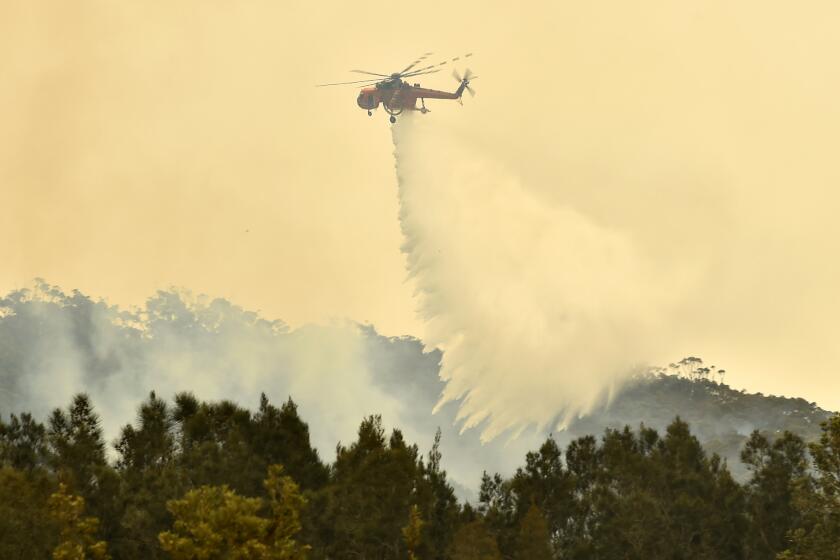 A helicopter dumps water on a wildfire outside the town of Batemans Bay in New South Wales, Australia, on Thursday.