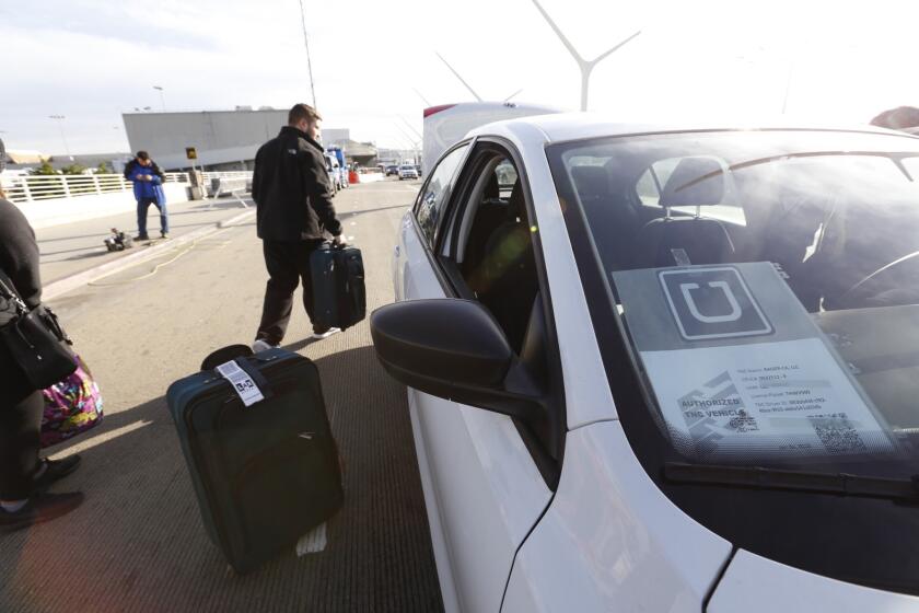 A passenger loads his suitcase into his UberX ride at Los Angeles International Airport.