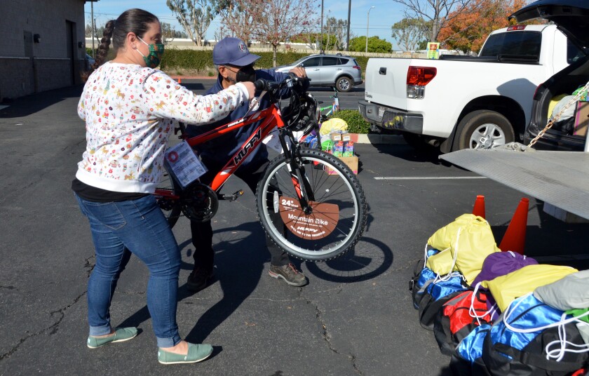 Gina Nunes and Adolfo Andrade load a bicycle donated by Bicycle Santas into a truck for distribution.