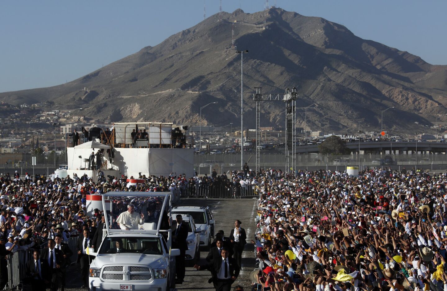 Pope Francis rides through the crowd Wednesday as El Paso, Texas, looms in the background at El Punto fairgrounds in Ciudad Juarez, Mexico.