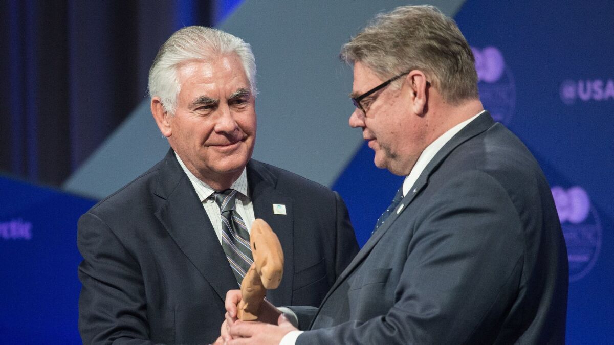 U.S. Secretary of State Rex Tillerson hands the Arctic Council chairman's gavel to Finnish Foreign Minister Timo Soini.