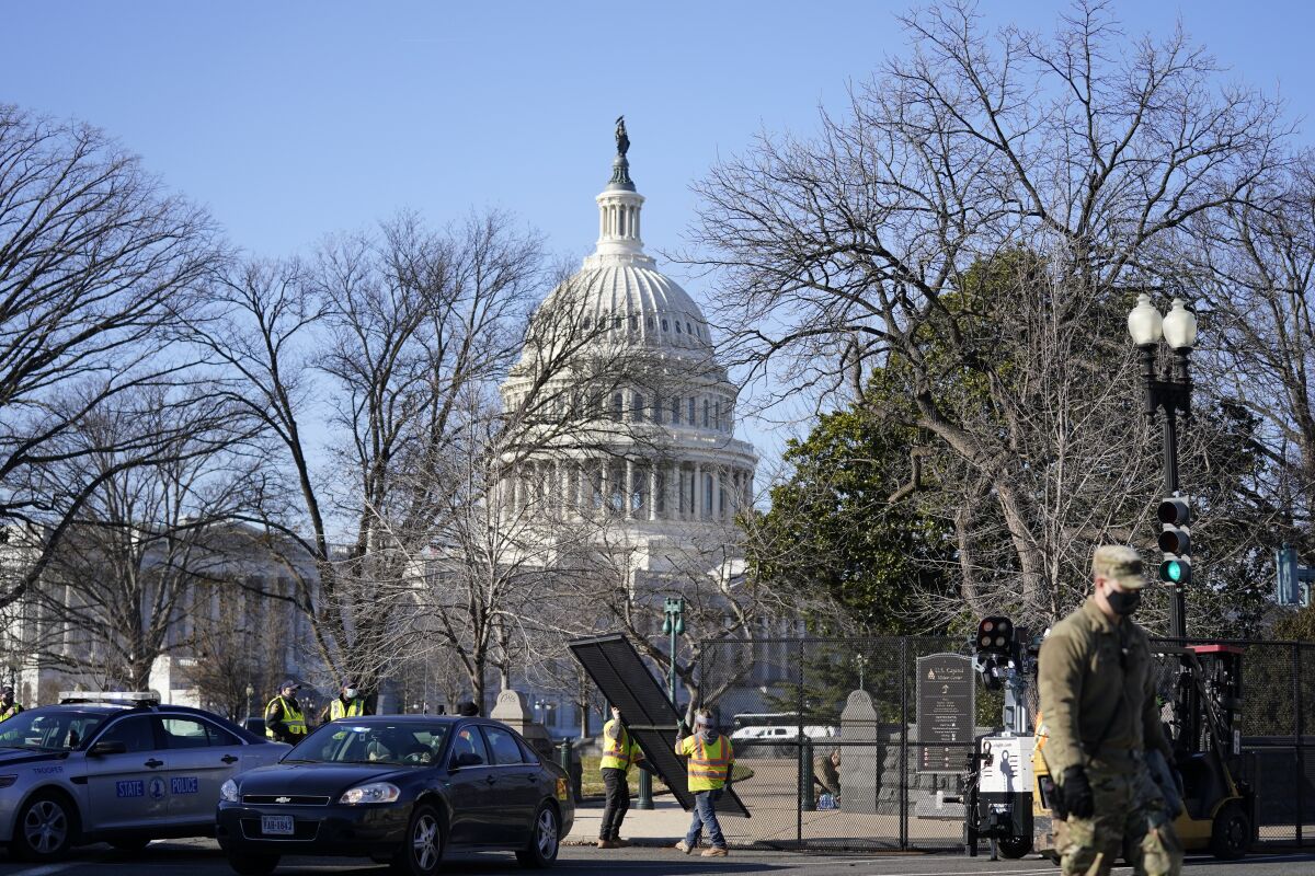 Workers install no-scale fencing around the U.S. Capitol on Thursday.