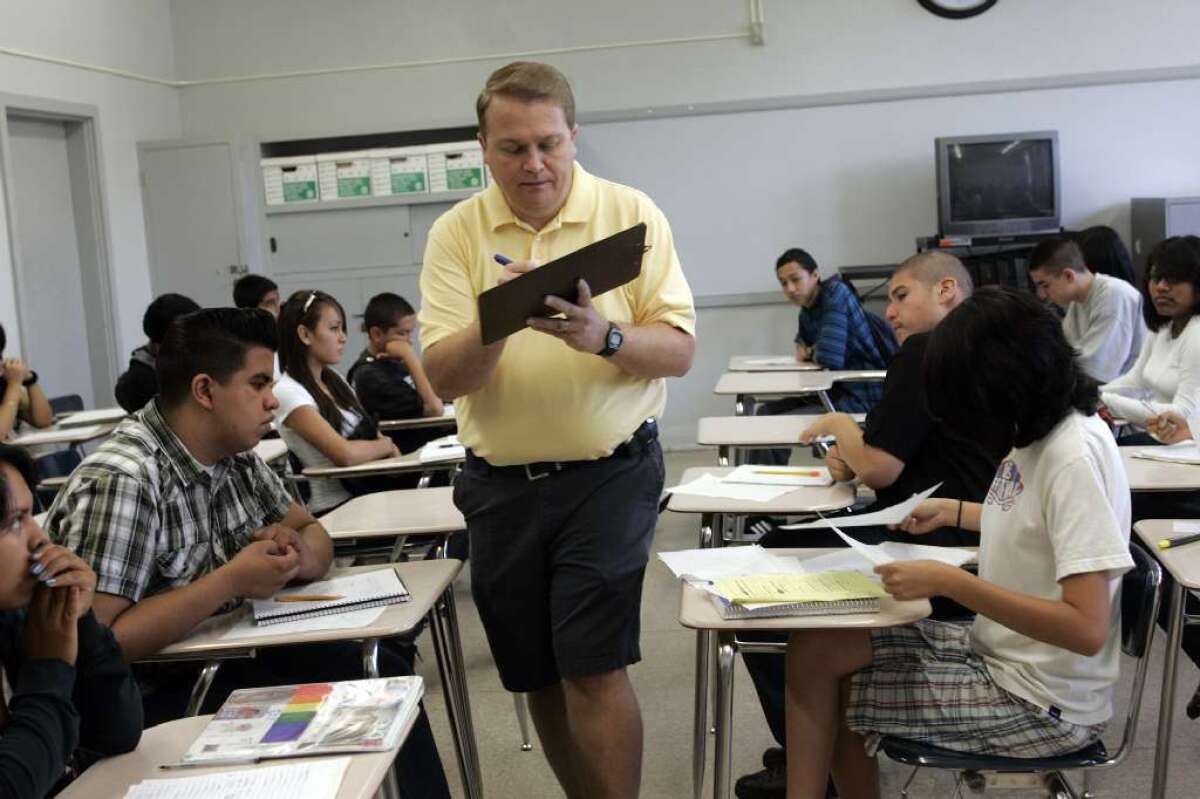 Brian York, algebra teacher at Monroe High School in North Hills, checks home work while students solve a problem in his summer school class in 2008. Monroe will be one of 16 high schools to offer credit recovery classes this summer.