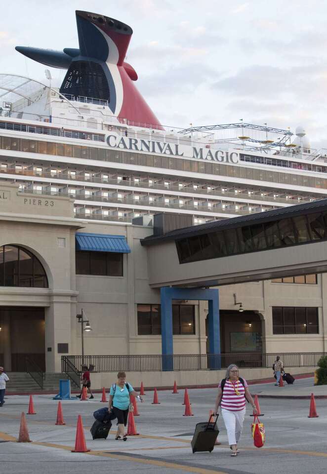 Passengers disembark from the Carnival Magic cruise ship after it reached port in Galveston, Texas