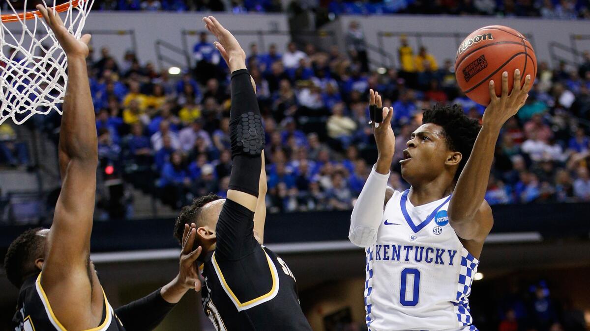 Kentucky guard De'Aaron Fox tries to score over Wichita State's Landry Shamet, center, and Shaquille Morris during the first half Sunday.