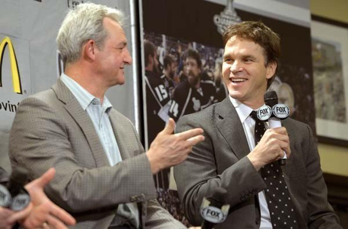 Coach Darryl Sutter and executive Luc Robitaille take part in the Kings' season-opening news conference last week at Staples Center.