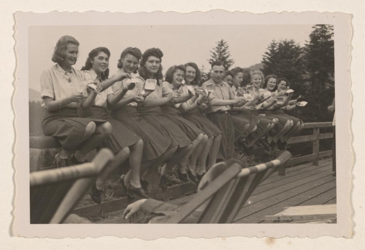 Auschwitz camp officer Karl-Friedrich Höcker, center, poses with women camp workers eating blueberries