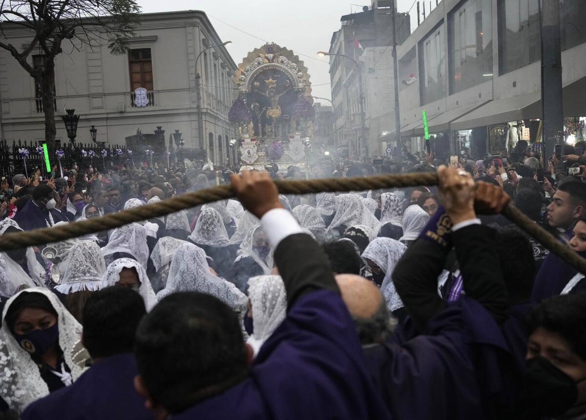 Mujeres con la cabeza cubierta por velos queman incienso durante una procesión 