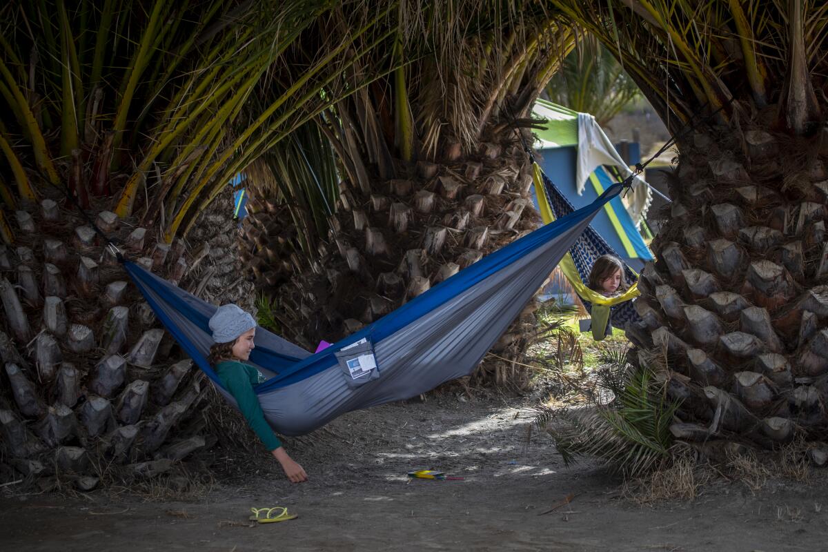 After hiking the Trans-Catalina Trail, young sisters rest in hammocks at their family's campsite.