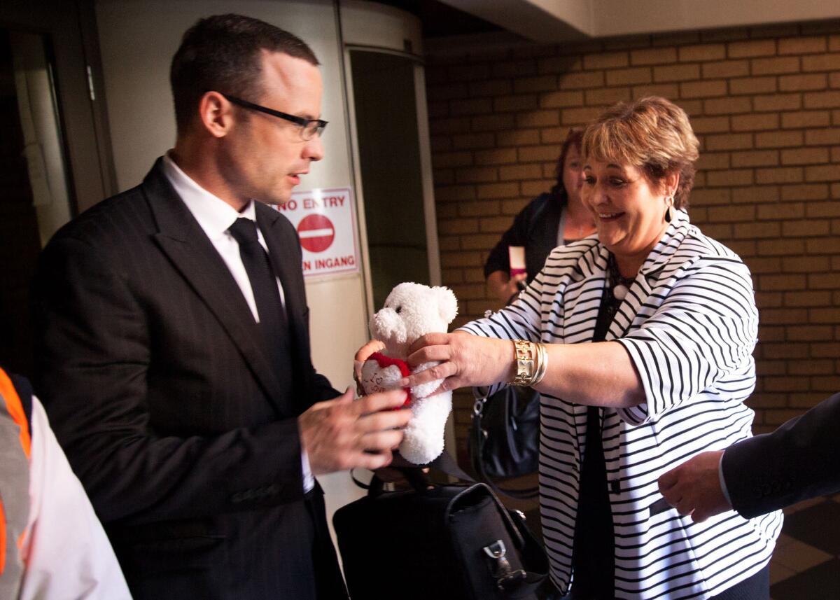 A supporter hands Oscar Pistorius a teddy bear in court during his murder trial in Pretoria, South Africa, on Tuesday.