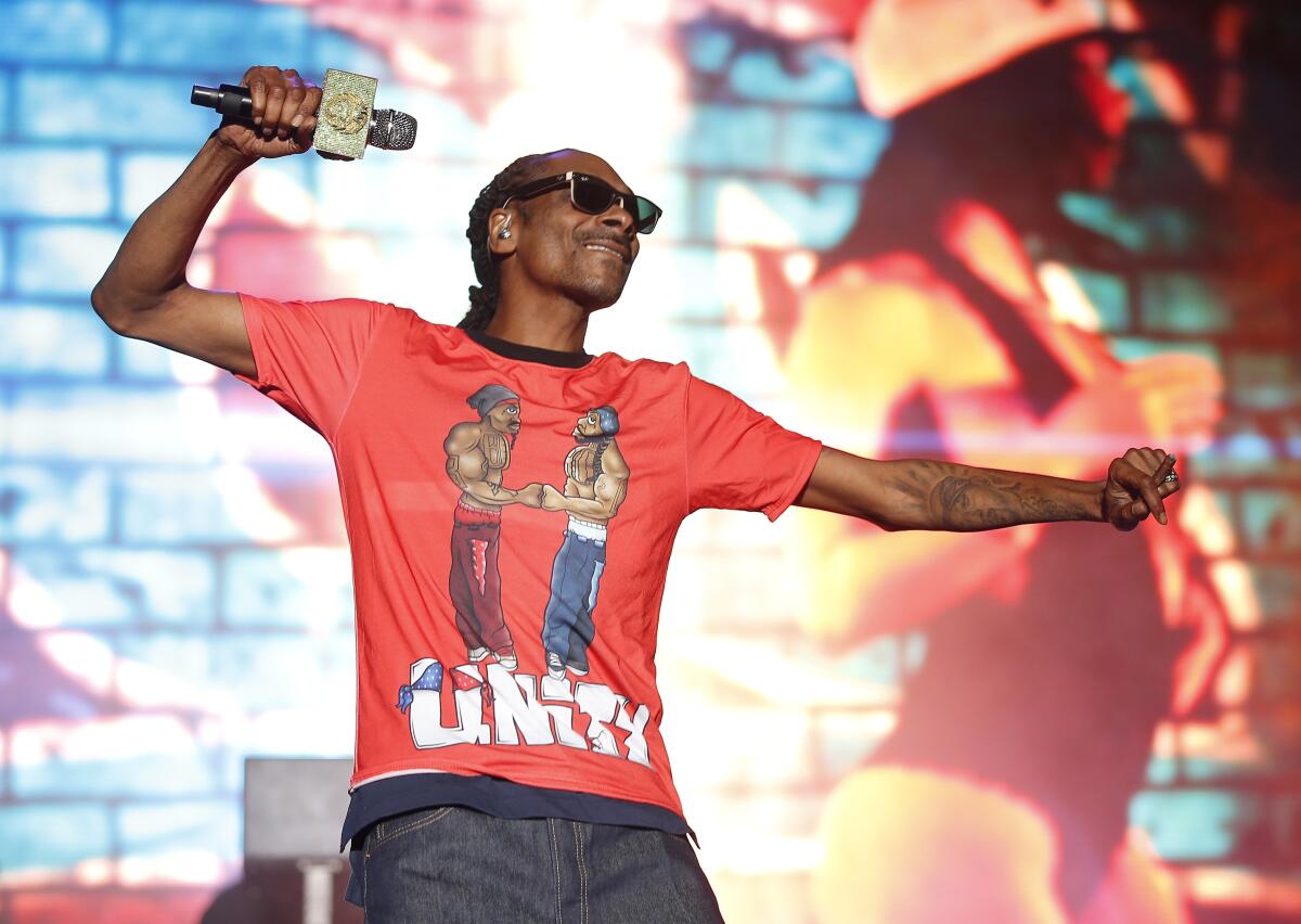 A rapper performing onstage in a T-shirt that says "Unity."