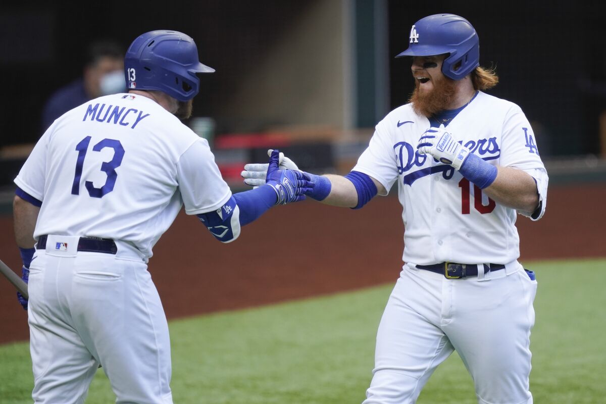Dodgers' Justin Turner celebrates with Max Muncy after hitting a home run against the Atlanta Braves.