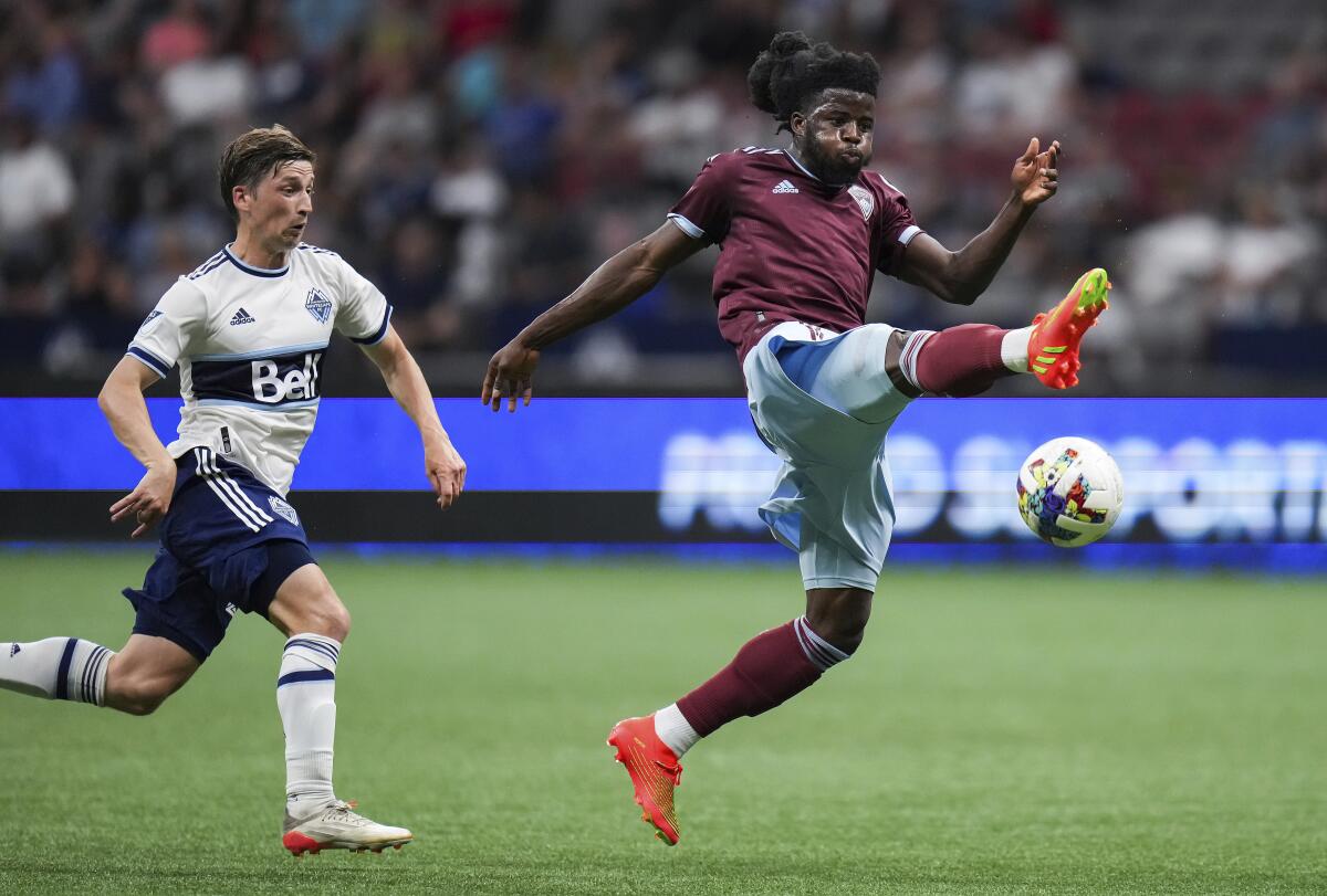 Colorado Rapids' Lalas Abubakar, right, and Vancouver Whitecaps' Ryan Gauld vie for the ball during the second half of an MLS soccer match Wednesday, Aug. 17, 2022, in Vancouver, British Columbia. (Darryl Dyck/The Canadian Press via AP)
