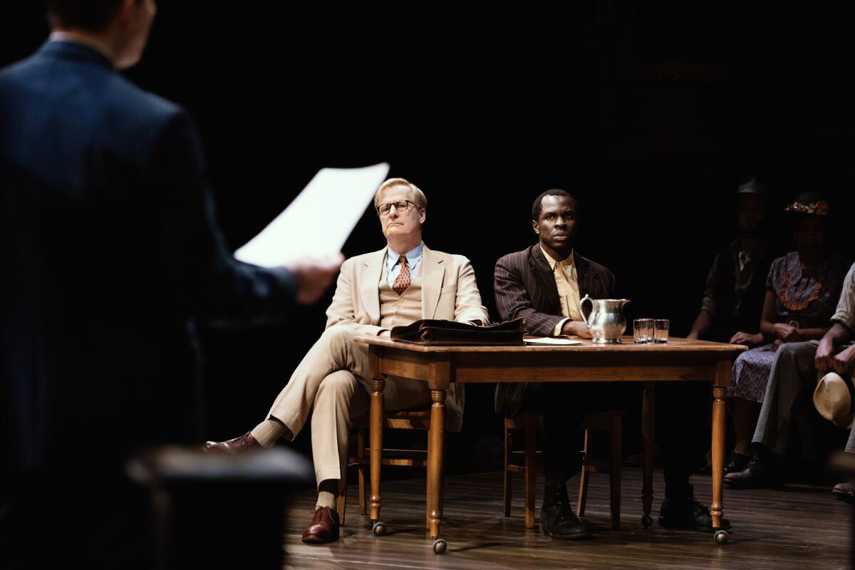 Jeff Daniels and Gbenga Akinnagbe sit at a desk in a courtroom in the Broadway production of "To Kill a Mockingbird."