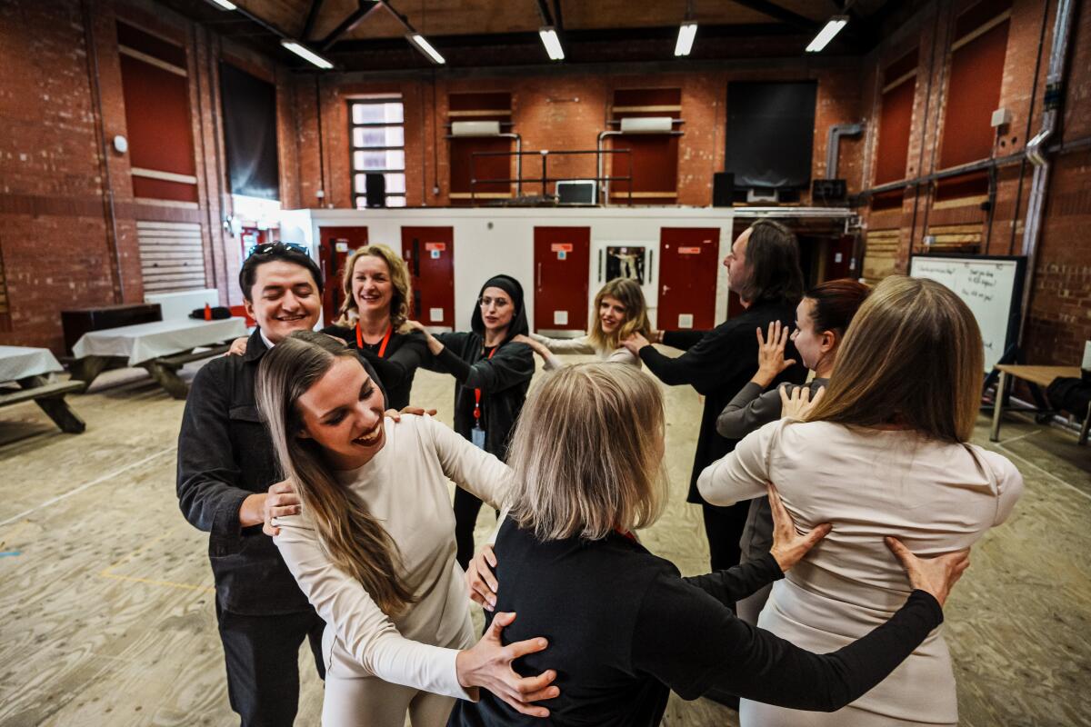 Ukrainian cast members give one another a back massage as they stand in a circle.