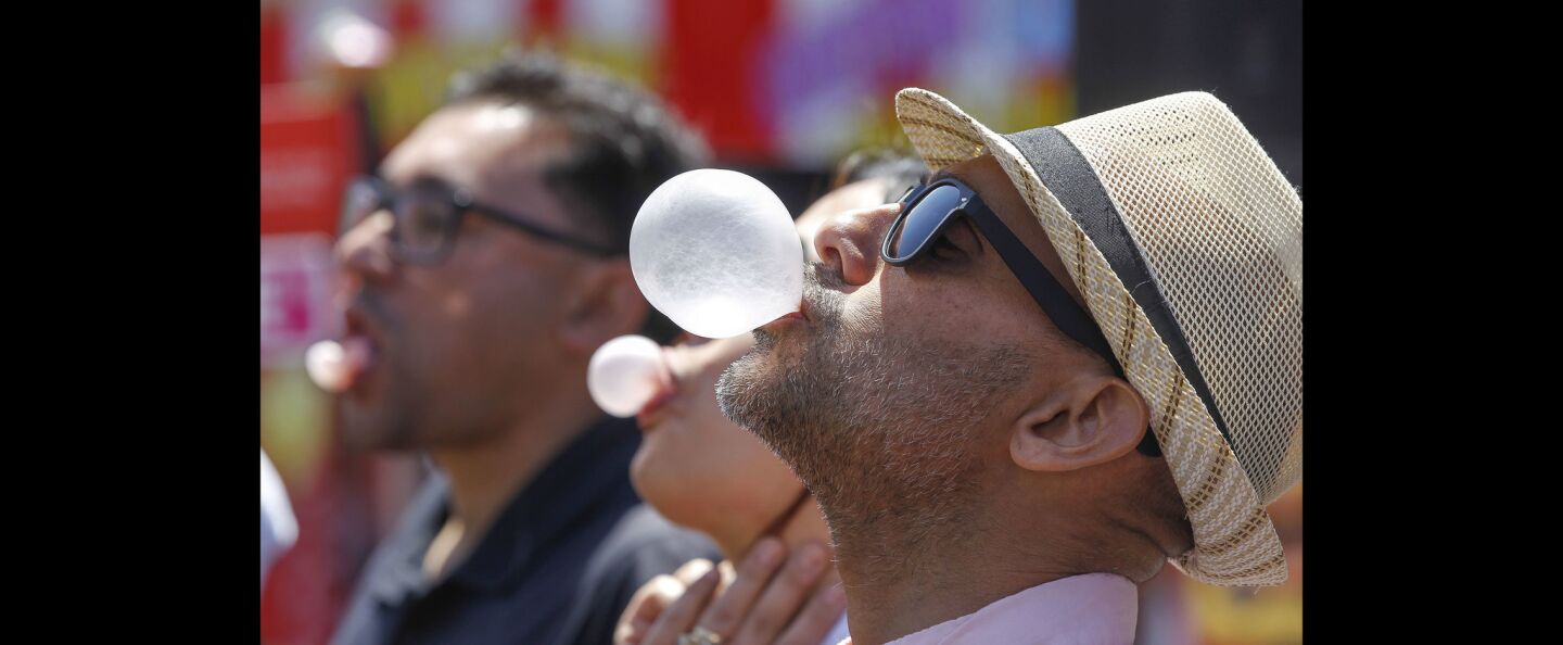 Zeji Ozeri blows a bubble as he and others compete in a bubble gum blowing contest.