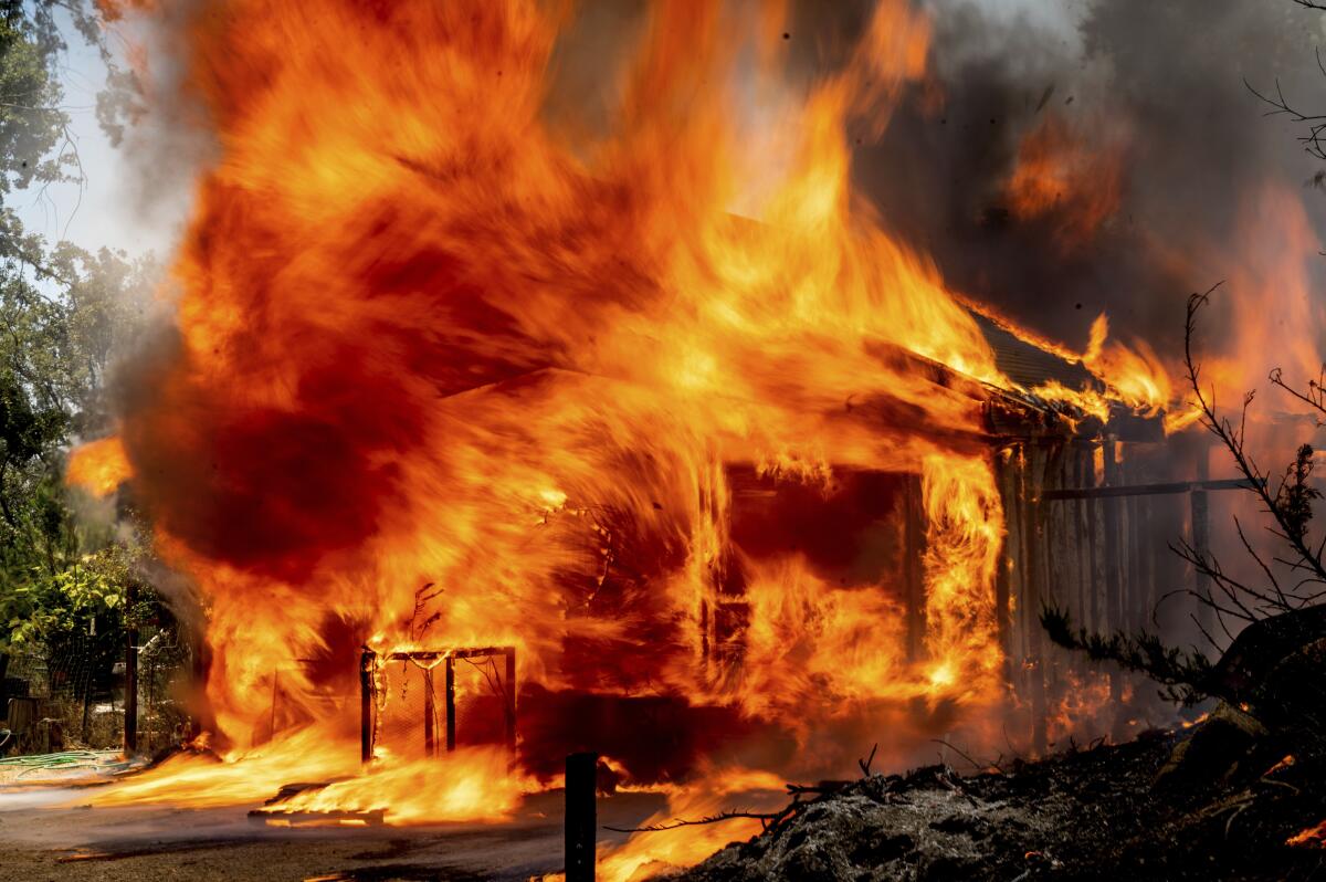 Flames consume a home on in Mariposa County, Calif., on July 23, 2022.