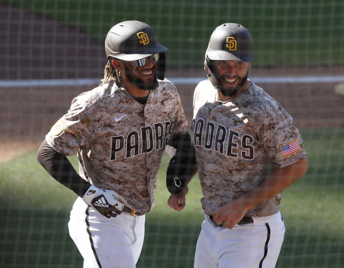 Padres teammates Fernando Tatis Jr. and Eric Hosmer celebrate after scoring.