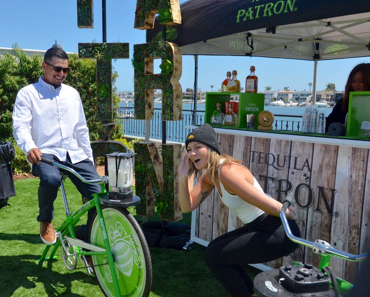 Austin Cervantes of Corona del Mar pedals the Patrón "margarita bike" as Cassandra Marquis listens.