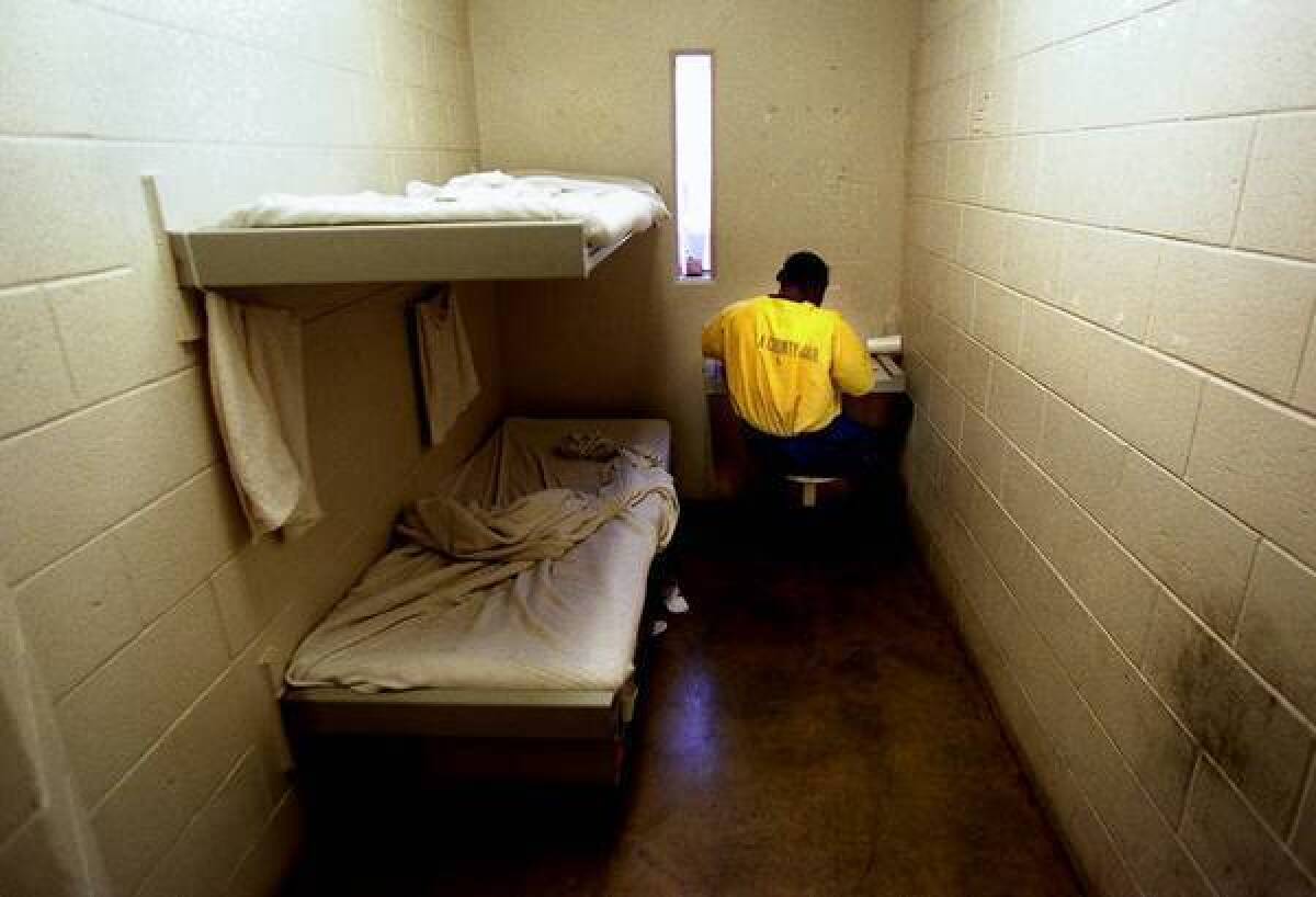 An inmate eats dinner in his cell at the Twin Towers jail in downtown Los Angeles. A Los Angeles County sheriff's jailer has been charged with assaulting two inmates, including one in the Twin Towers.