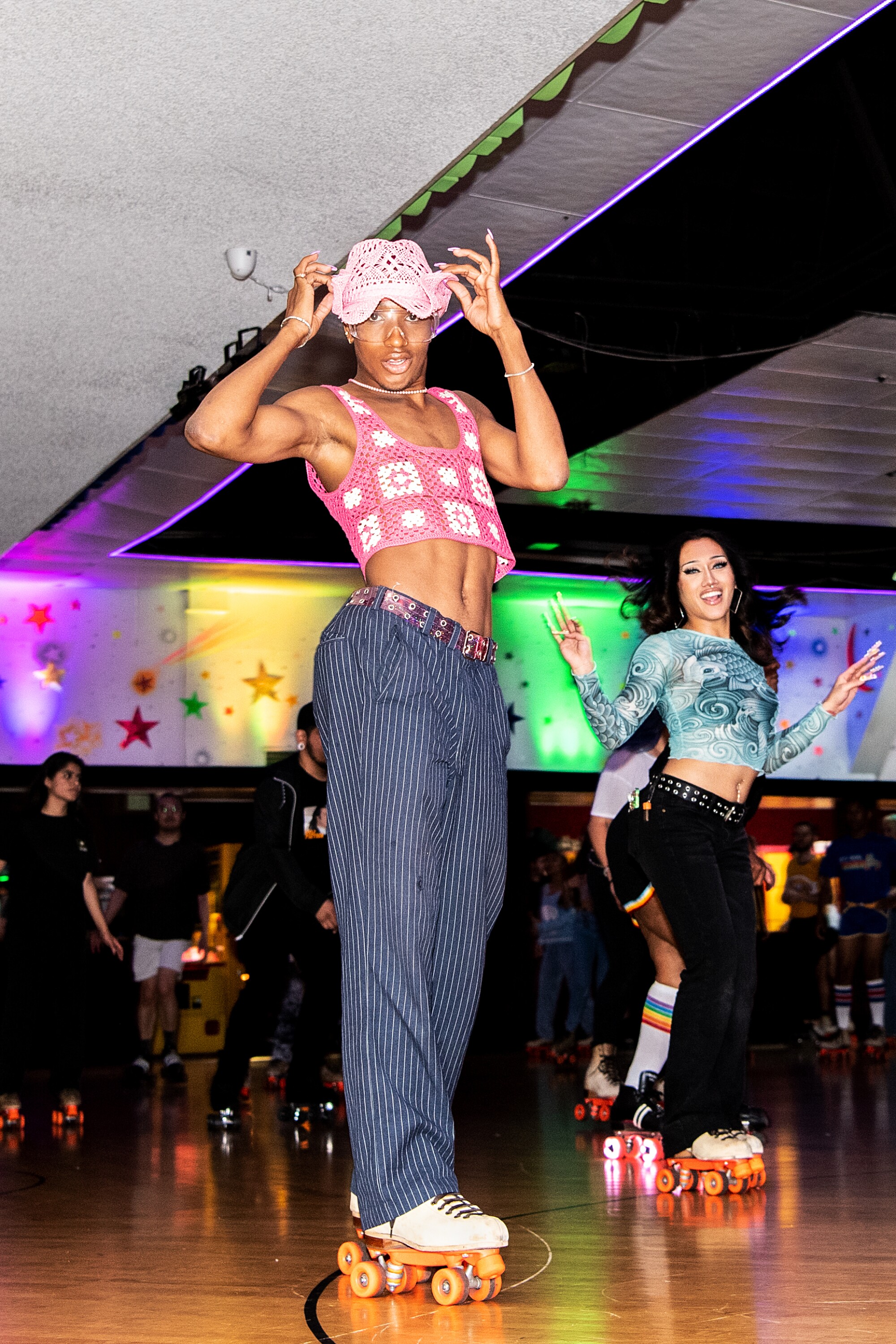 A couple of people strike a pose in the middle of the roller rink.