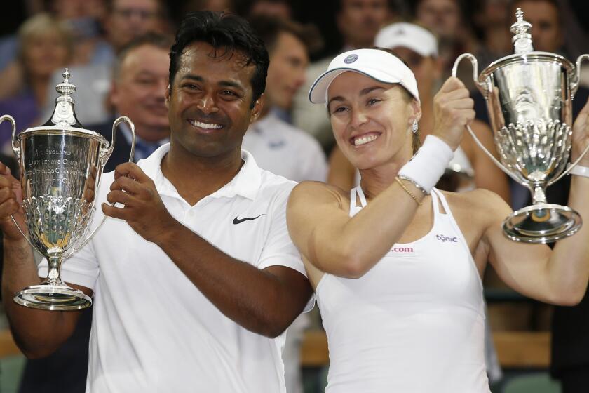 Leander Paes, left, and Martina Hingis celebrate their mixed doubles championship victory at Wimbledon on Sunday.