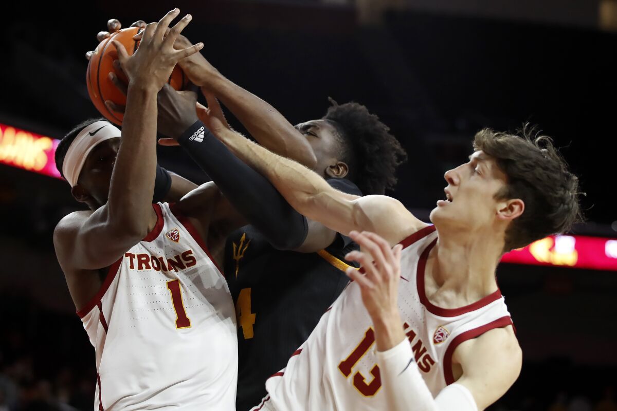 USC forward Chevez Goodwin and guard Drew Peterson battle Arizona State center Enoch Boakye for the ball.
