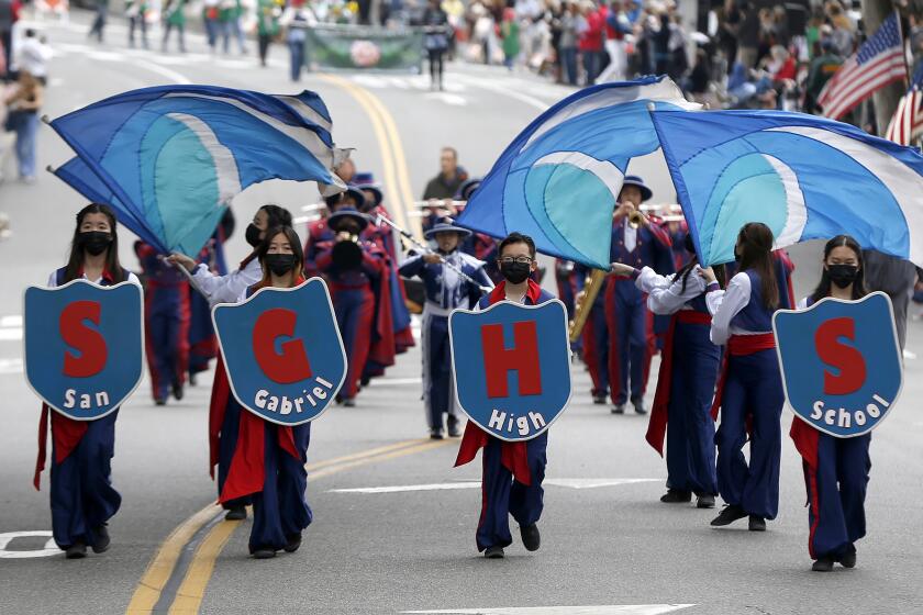The San Gabriel High School marching band play and swing banners in the 56th annual Patriot's Day Parade in Laguna Beach on Saturday.