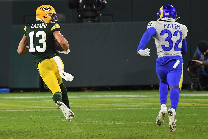 GREEN BAY, WISCONSIN JANUARY 16, 2021-Packers receiver Allen Lazard beats Rams safety Jordan Fuller to the end zone for a touchdown after a catch in the 4th quarter during a playoff game at Lambeau Field in Green Bay Saturday. (Wally Skalij/Los Angeles Times)